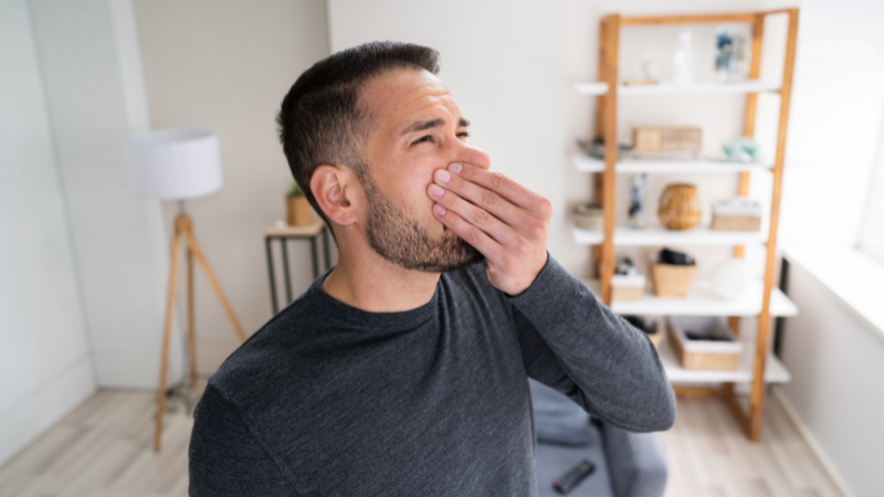 Man covering nose due to unpleasant odor in home